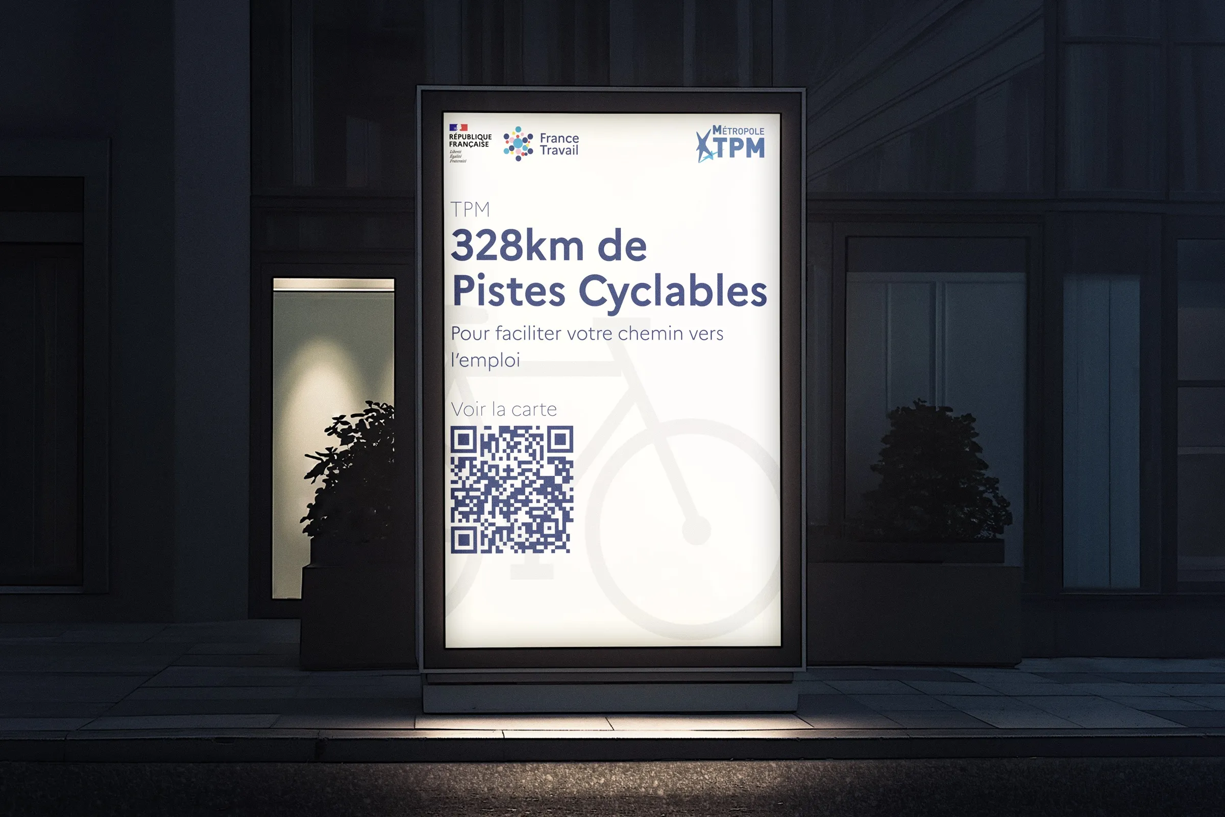 Affiche « 328 km de pistes cyclables » avec QR code, dans un caisson lumineux la nuit