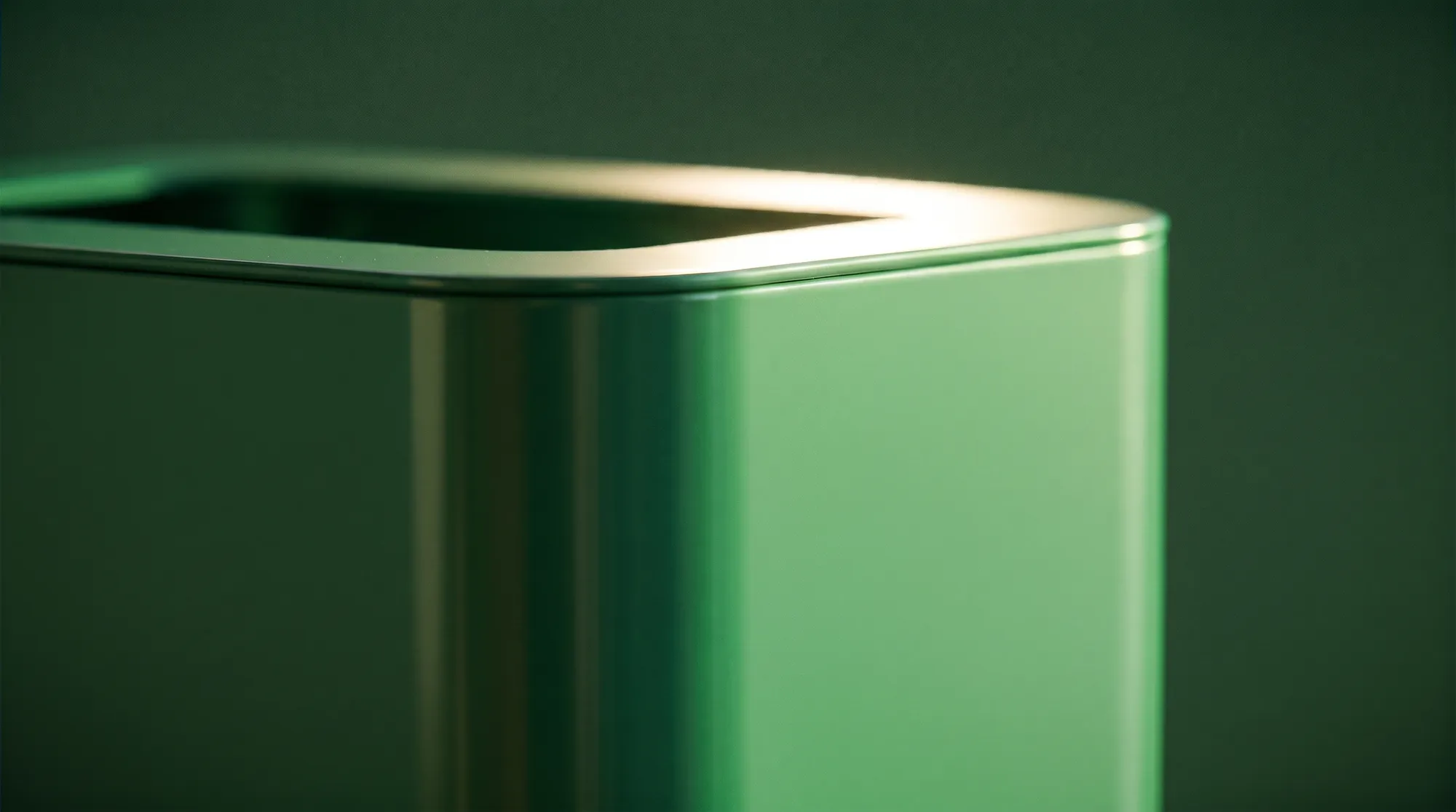 Détail macro d'un angle de poubelle KITA verte, jeu de reflets sur l'acier